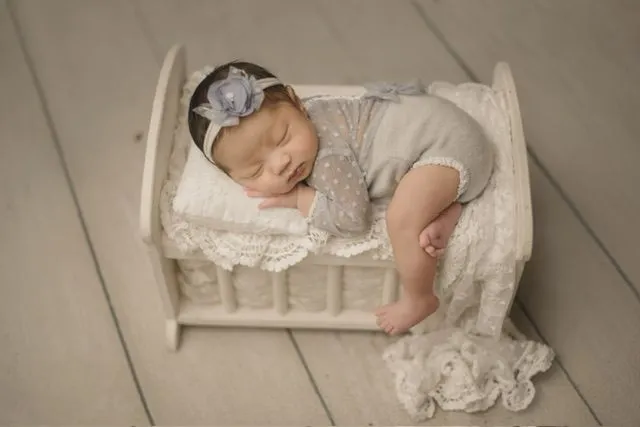 Baby laying on a small bed