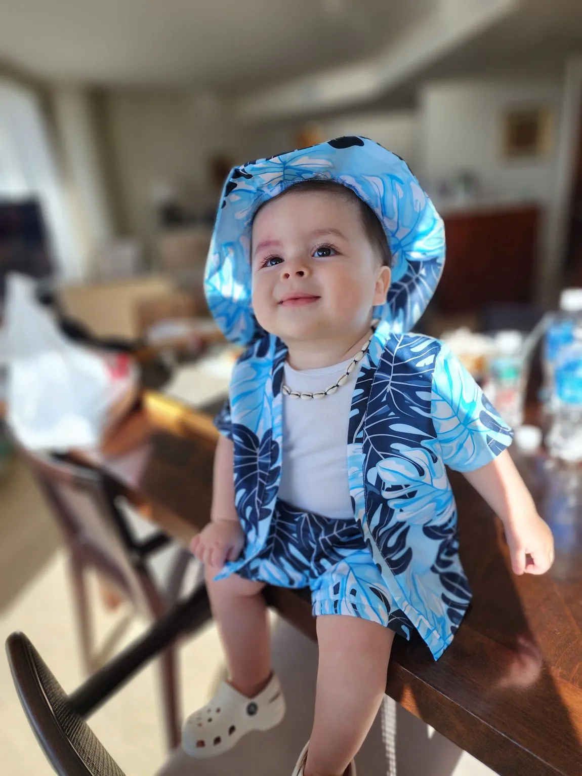 Smiling baby in a blue outfit and hat