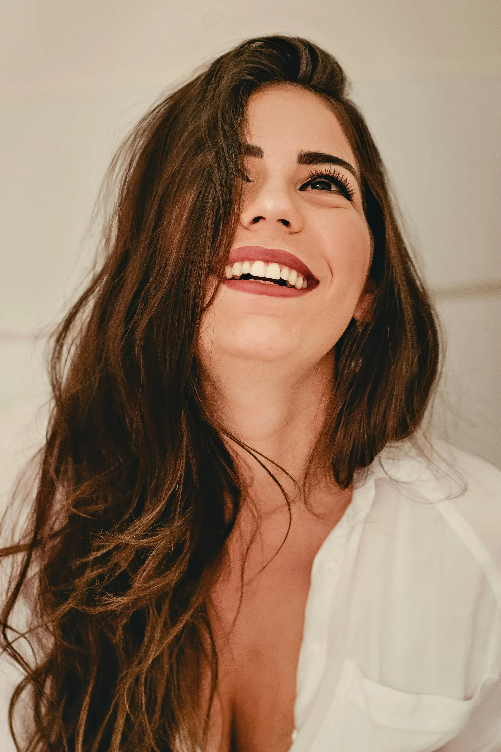 women looking up happily with beige background
